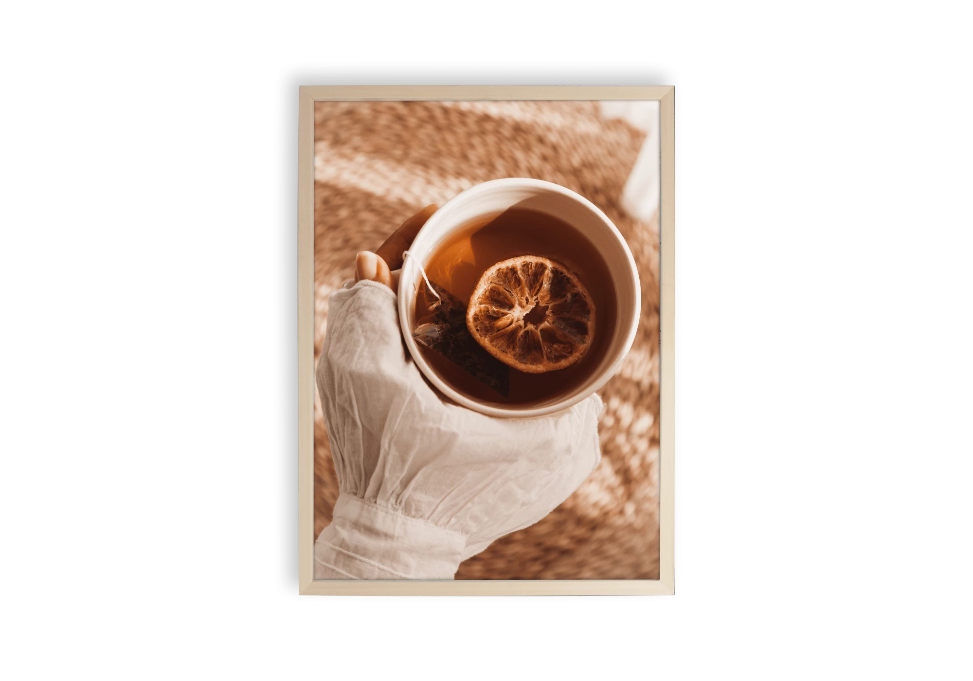 Affiche d'une tasse thé tenue dans une main avec à l'intérieur une rondelle d'orange.