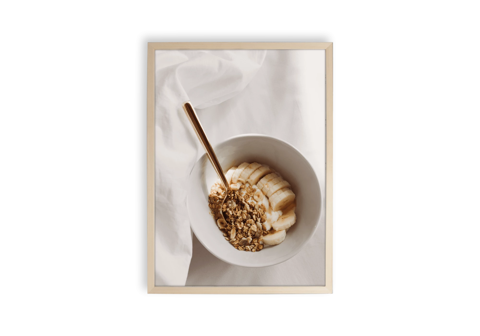 Photographie d'un bol de petit-déjeuner rempli de musli et de banane coupée en rondelle avec sa cuillère.